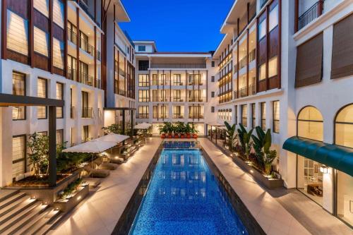 坎多林The Astor - All Suites Hotel Candolim Goa的一座位于大楼中间的室内游泳池
