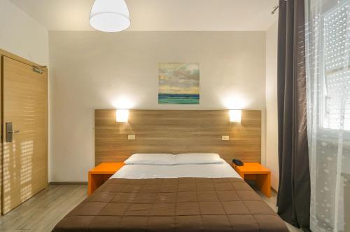 比萨国会大厦酒店的一间卧室配有一张大床和两张桌子