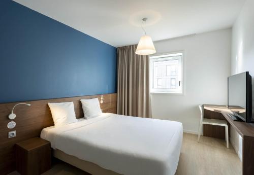 圣纳泽尔B&B HOTEL Saint-Nazaire Pornichet的配有一张床和一张书桌的酒店客房