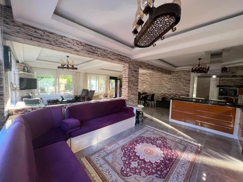 Çamlarkent Villaları的一间带紫色沙发的客厅和一间厨房