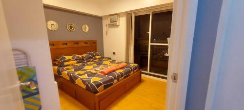 马尼拉Cozy and Big Unit in Torre de Manila的一间卧室配有带橙色枕头的床