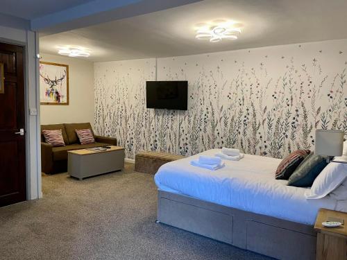 罗斯伯里土耳其头罗斯伯里宾馆的一间卧室配有一张床、一台电视和一张沙发