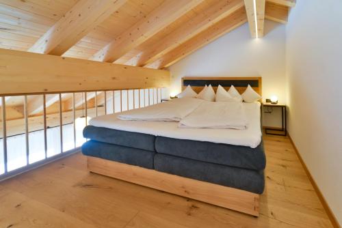 达米尔斯Haus Margrith Alpenblick Appartements的阁楼设有1间带1张床的卧室和木制天花板