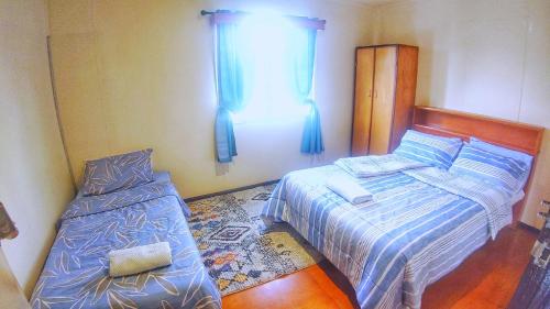 哈根山Shalom Mission Home的一间卧室设有两张床和窗户。