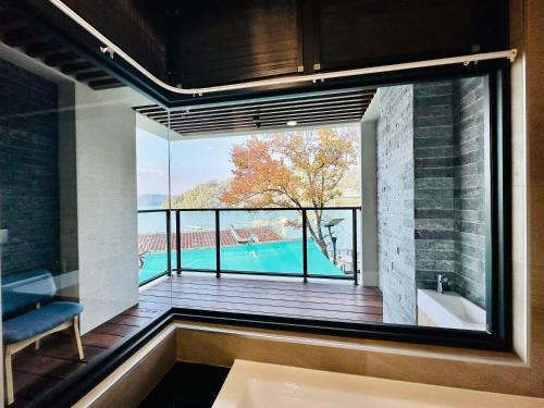 鱼池乡水秀一方Sun Moon Lakeside Boutique Hotel的浴室设有大窗户,享有游泳池的景致。
