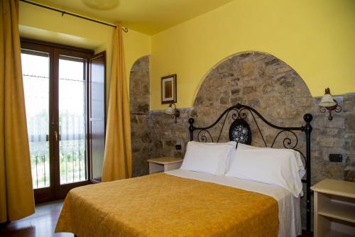 TrivignoLa Foresteria di San Leo的一间卧室设有一张床和石墙