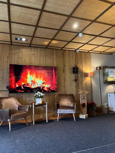 吕登沙伊德斯波特艾姆吉费卢克酒店的客厅配有两把椅子和壁炉