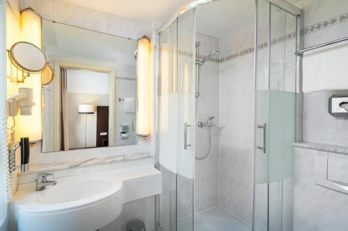 柏林Leonardo Hotel Berlin KU'DAMM的一间带水槽和淋浴的浴室