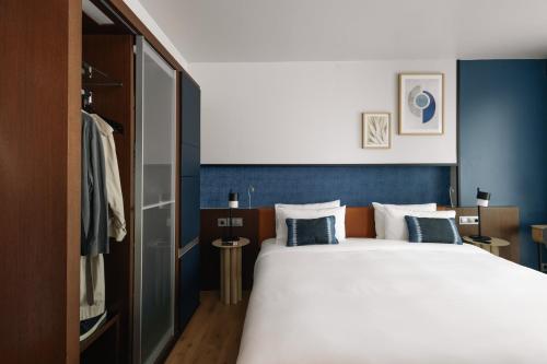 马德里Crowne Plaza Madrid - Centre Retiro, an IHG Hotel的一间卧室配有一张带蓝色墙壁的大床