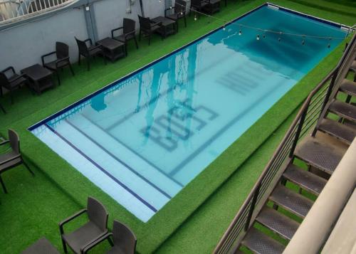 拉各斯BOSS HOTELS & SUITES的游泳池顶部美景,设有椅子