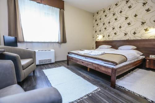 FehérvárcsurgóGránátalma Vendégház的一间卧室配有一张床、一张沙发和一个窗口