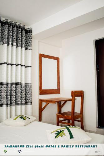 韦勒沃耶Tamarind Tree House的客房设有两张床、一张桌子和镜子