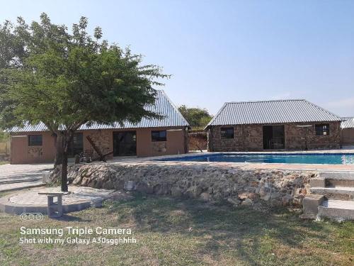 曼齐尼Inkwazi Getaway Lodge的一座带游泳池和树的房子