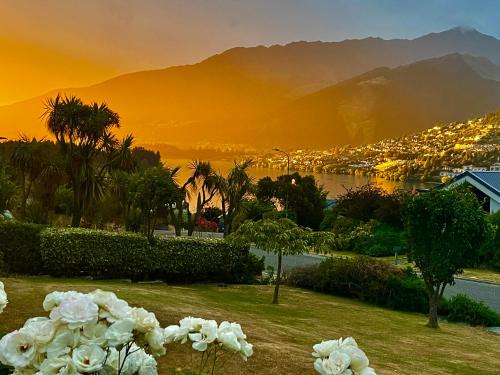 皇后镇Kelvin Garden Villa的享有带山脉和白色鲜花的城市美景