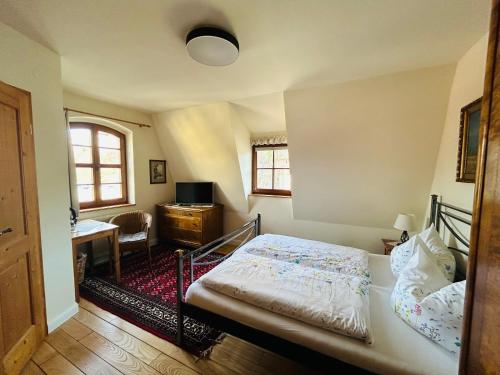 包岑阿尔特格伯莱酒店的一间卧室配有一张床、一张书桌和窗户。