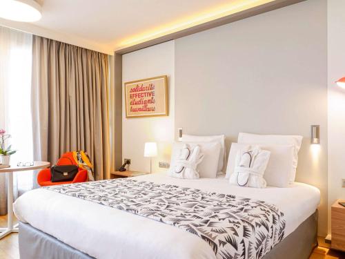 马赛马赛美居中心普拉多赛车场酒店的酒店客房配有一张带白色枕头的大床