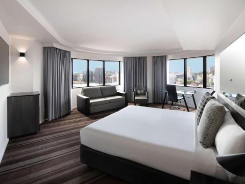 悉尼悉尼美居酒店的酒店客房,配有床和沙发