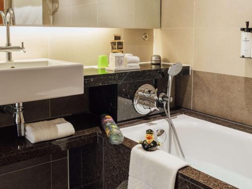 希灵登索菲特伦敦希斯罗酒店的带浴缸和盥洗盆的浴室