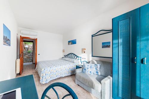 伊斯基亚Punta Chiarito Resort的一间卧室配有一张床、一张沙发和一把椅子