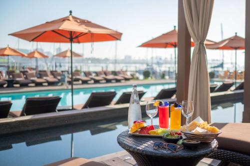 长滩玛雅酒店 - 希尔顿逸林酒店的一张桌子,旁边是一张带食物和饮料的盘子