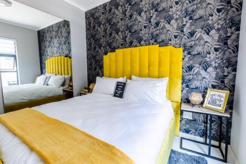 米德兰Central Serenity @Midrand的一间卧室配有一张带黄色床头板的大床