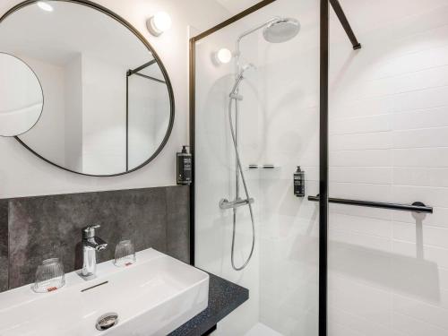 布达佩斯ibis Budapest Stadium的浴室配有盥洗盆和带镜子的淋浴