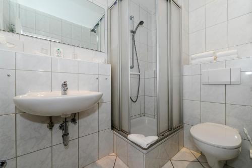 威克奥夫弗尔Kurhaus Hotel的带淋浴、盥洗盆和卫生间的浴室