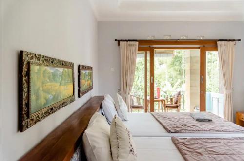 乌布乌布阿尔加旅馆的卧室设有一张白色大床和一扇窗户。