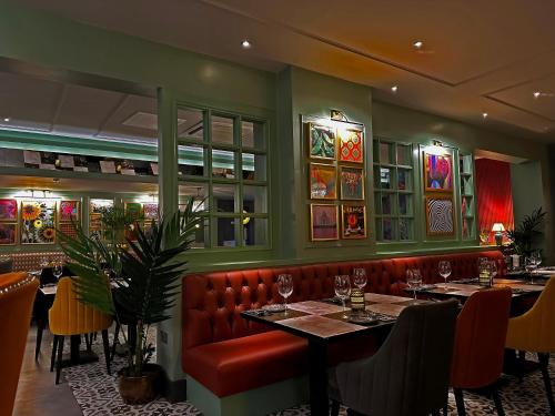 泰恩河畔纽卡斯尔贝斯特韦斯特新肯特酒店的一间设有两张桌子和红色皮革座椅的餐厅