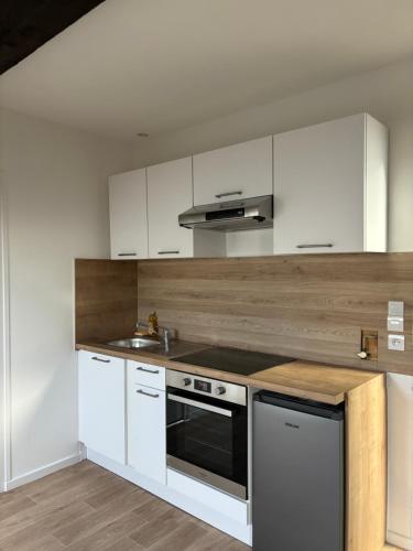 瓦朗斯Le Maurice - appartement centre-ville的厨房配有白色橱柜和炉灶烤箱。