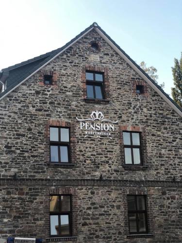 马格德堡Pension Westerhuesen的砖砌的建筑,旁边标有标志