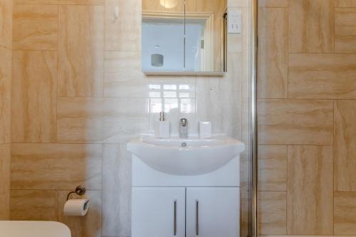 埃奇韦尔Room in Guest room - Apple House Wembley的浴室配有白色水槽和淋浴。