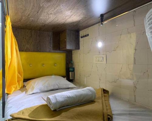 孟买Neenava Dormitory Asalpha的一张床上,有一个黄色床头板