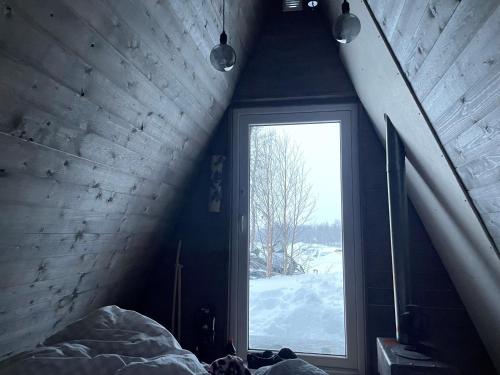 BorgafjällGlamping wooden house的一间卧室,卧室内有窗户,房间下雪