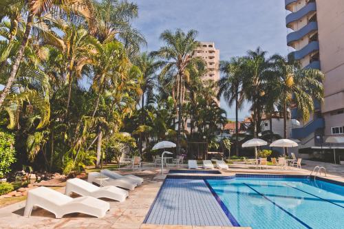 阿拉拉夸拉莫拉达杜索尔格兰酒店的一个带躺椅的游泳池,棕榈树