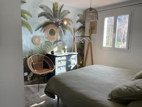 马赛La Calanq'Aise的一间卧室配有床、梳妆台和棕榈树壁画