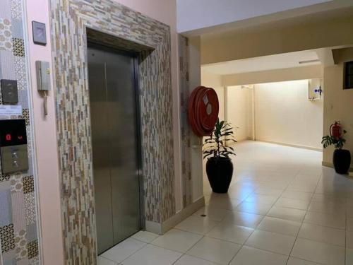 内罗毕Spire Plaza 2 bedroom apartment的走廊上装有玻璃门,里面装有植物
