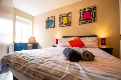班多伦Peak View Apartment Main Beach的卧室配有一张带枕头的床和墙上的海报