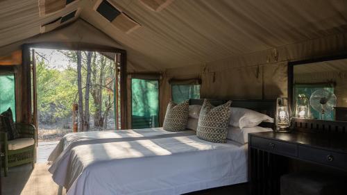 LentswelemoritiMashatu Tent Camp的帐篷内一间卧室,配有一张大床