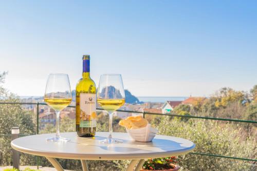 东塞斯特里Villa Chicchi - Sestri Levante的一张桌子,上面放着两杯白葡萄酒和面包