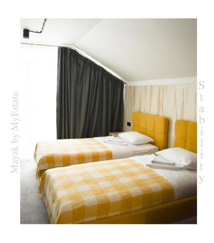 亚布卢尼齐亚Aparthotel "Mayak Yablunytsia"的两张睡床彼此相邻,位于一个房间里