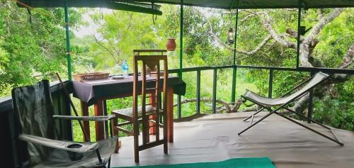 Bundala LevagamgodaJungle Cabin的门廊上配有桌椅的房间