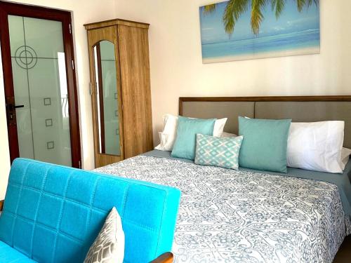 康隆尼角Residence Le Point Choisy的一间卧室配有蓝色的床和蓝色的沙发