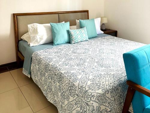 康隆尼角Residence Le Point Choisy的一间卧室配有一张带蓝色和白色枕头的床