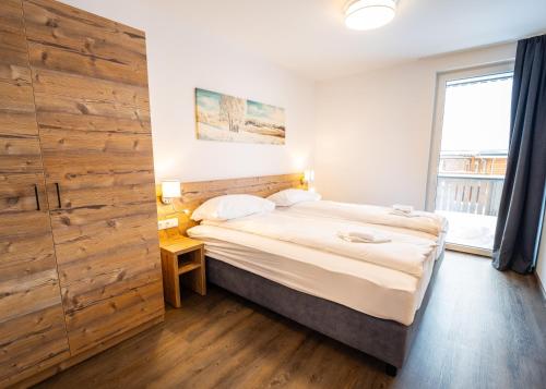 卡奇山口Haus Tauernblick Katschberg by AlpenTravel的一间卧室设有一张床和木墙