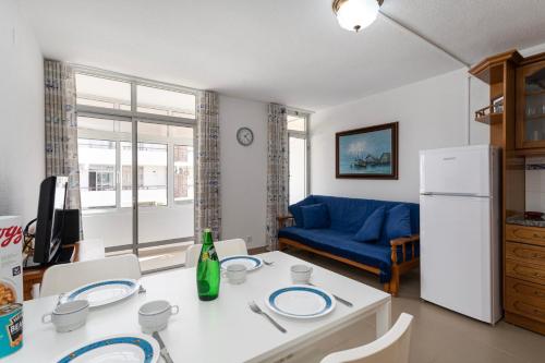 阿尔布费拉TAC - Fisherman's Beach Apartment的客厅配有桌子和蓝色沙发
