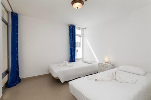 阿尔布费拉TAC - Fisherman's Beach Apartment的白色客房的两张床,设有窗户