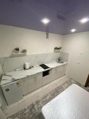 乌斯季卡缅诺戈尔斯克Однокомнатные апартаменты的厨房配有白色橱柜和台面