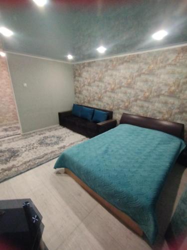 乌斯季卡缅诺戈尔斯克Однокомнатные апартаменты的一间卧室配有一张床和一张沙发