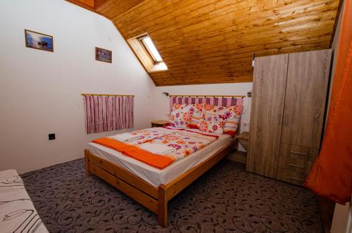 克韦什卡尔Bánóporta的一间小卧室,配有一张床和木制天花板